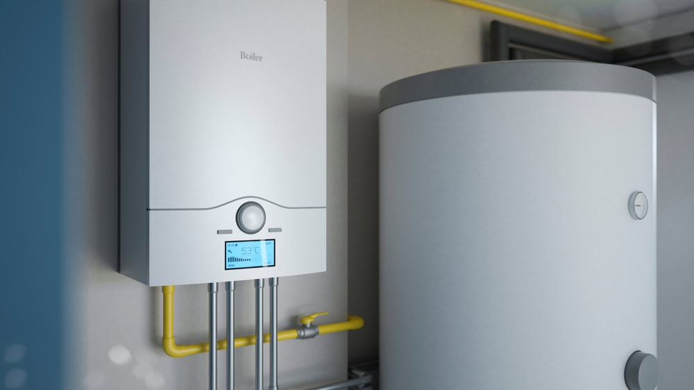 This image shows a modern boiler system with a digital display indicating a temperature of 50°C. It is mounted on a wall next to a large cylindrical water tank. Yellow pipes are visible, suggesting a heating setup.